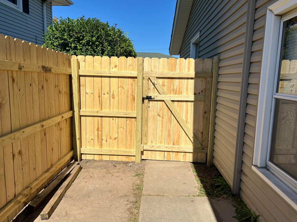 Wooden privacy fence built by IW Brothers LLC in a residential backyard.
